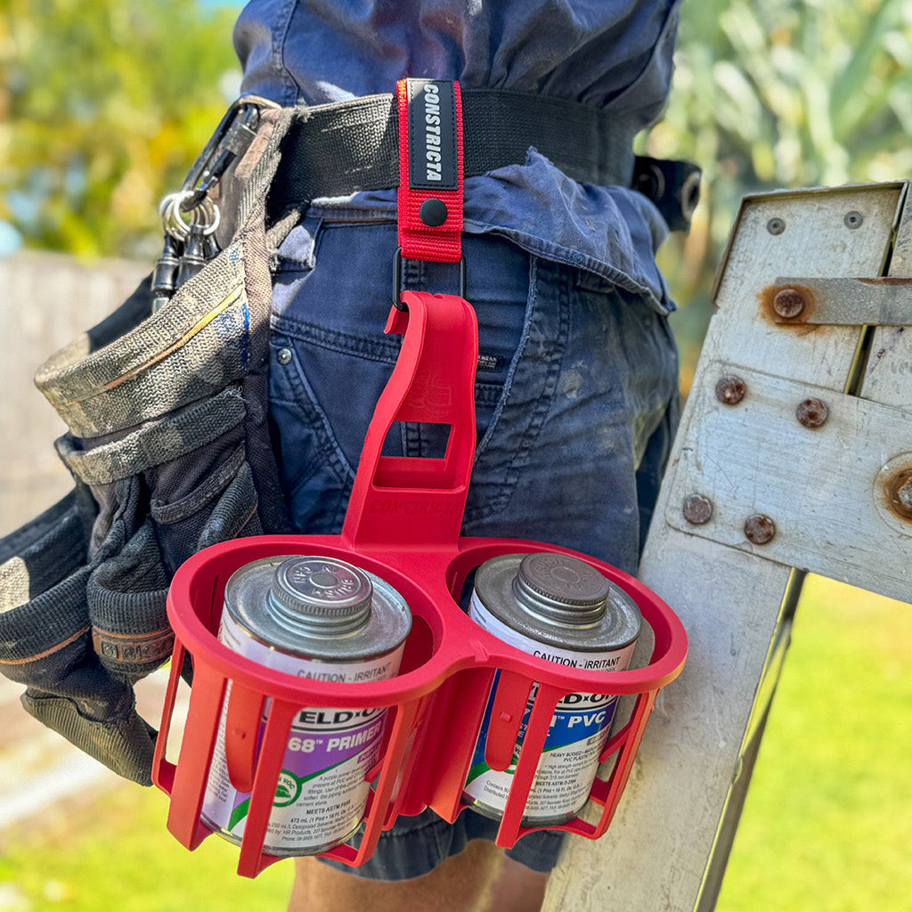 Red Glue Pot Caddy 
Constricta Multi Pot Grip adjusts to securely hold two containers of varying sizes (80mm to 115mm).
Constricta Multi Pot Grip is ideal for use in elevated situations as well as in the trenches making it the perfect solution for Plumbers, Electricians, Pool Technicians and any Tradesperson that requires pots secured whilst working or storing.  
Benefits of the Constricta:
Hook handle for easy carrying and hanging on structures
Channel slot for securing on fa