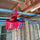 Red bottle holder with two bottles hanging from a metal beam in a construction setting.