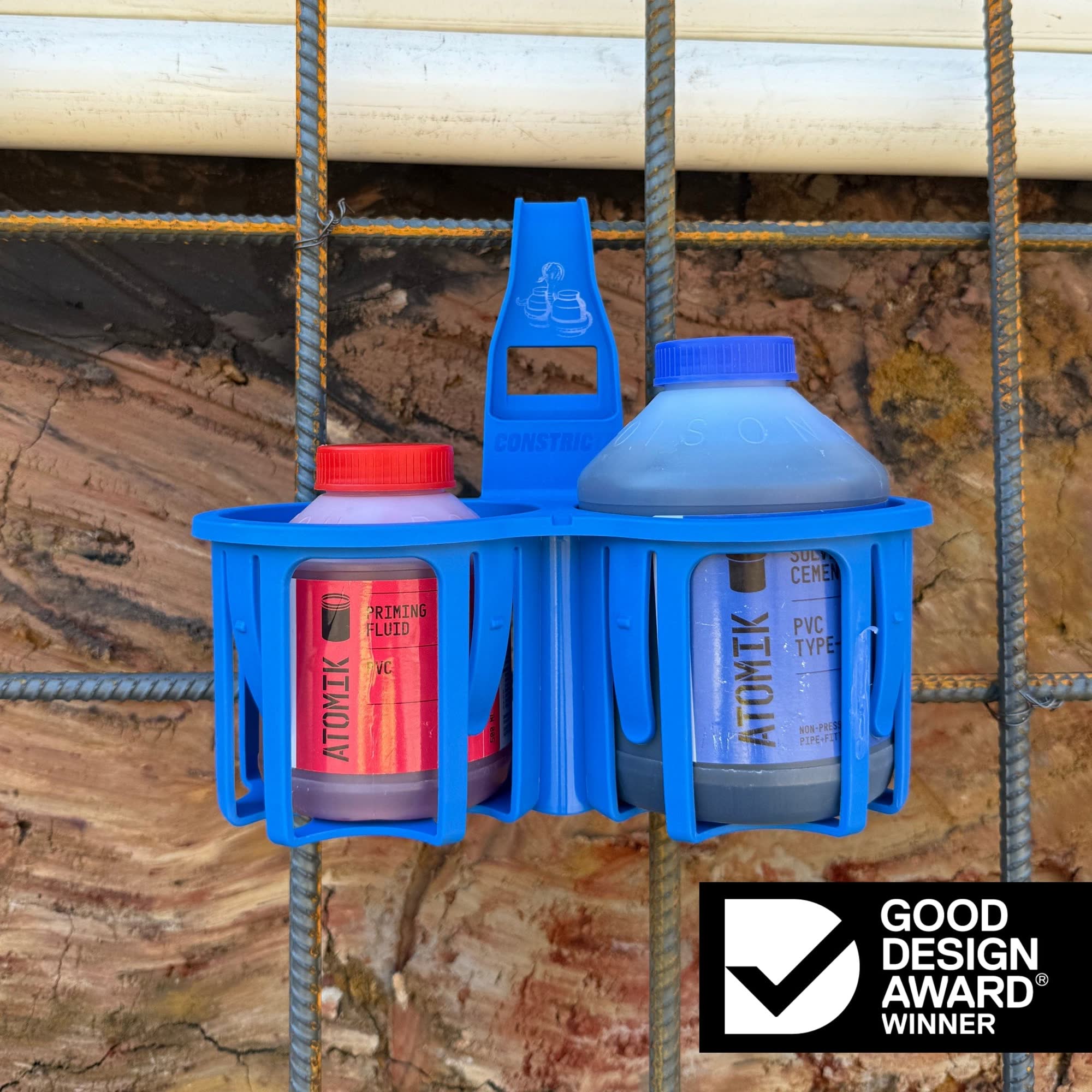 Blue bottle holder with two bottles against a wooden background, featuring a Good Design Award logo.